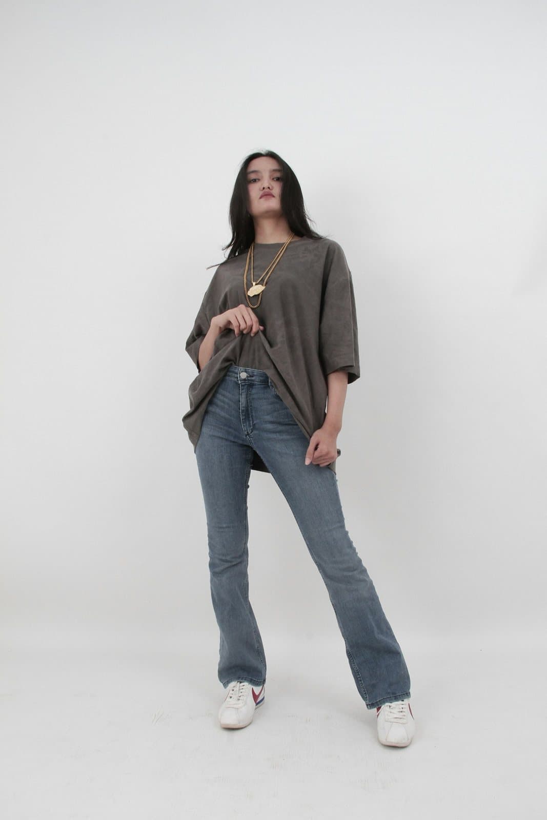An outfit photo of a grey oversized T-shirt and flared jeans